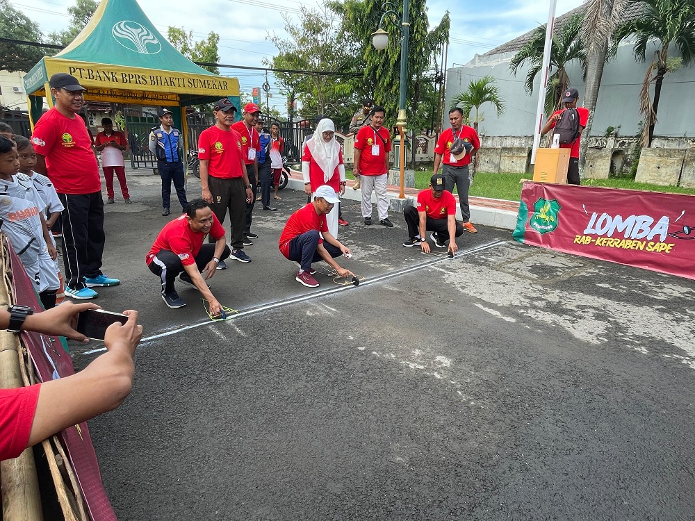 LESTARIKAN TRADISI: Kepala Dispendik Sumenep Agus Dwi Saputra (kiri) dan Sekkab Edy Rasiyadi mencoba permainan tradisional rap-kerraban saat pembukaan turnamen di halaman pemkab, Jumat (26/1).