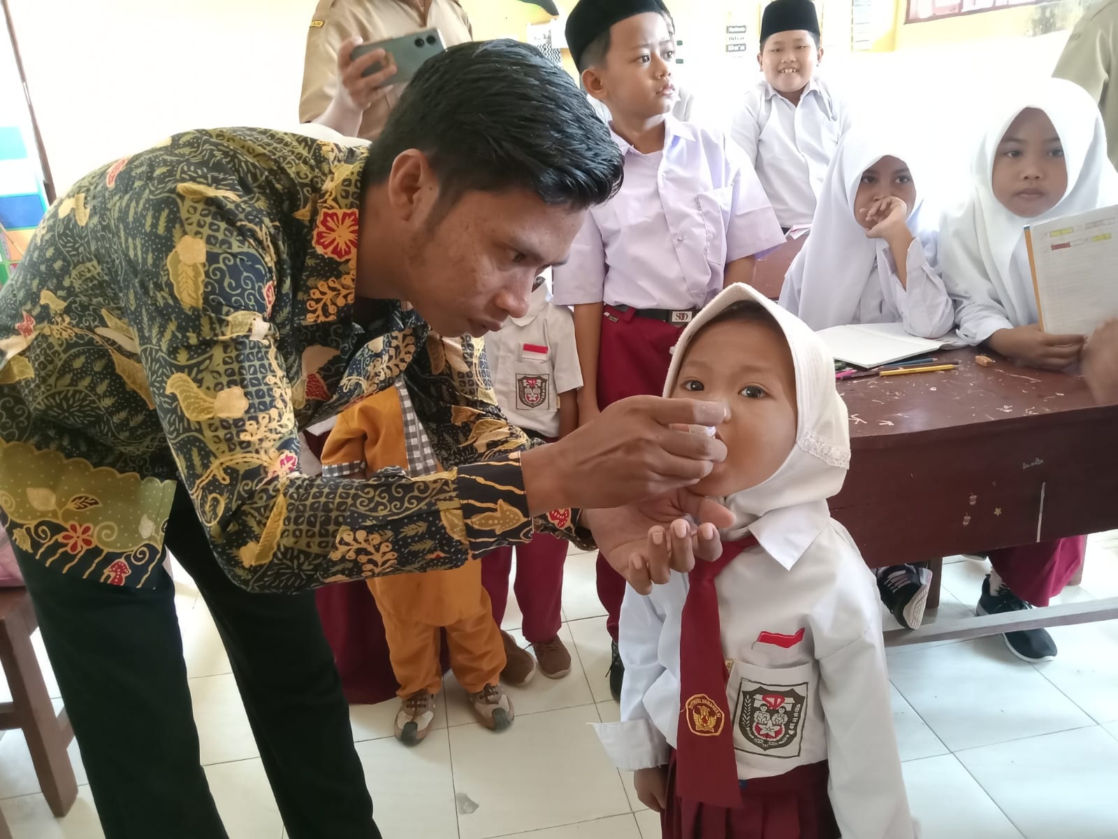 CEGAH POLIO: Tenaga kesehatan puskesmas melakukan imunisasi polio terhadap siswa SD di Kecamatan Batuputih, Sumenep. (PUSKESMAS BATUPUTIH UNTUK JPRM)