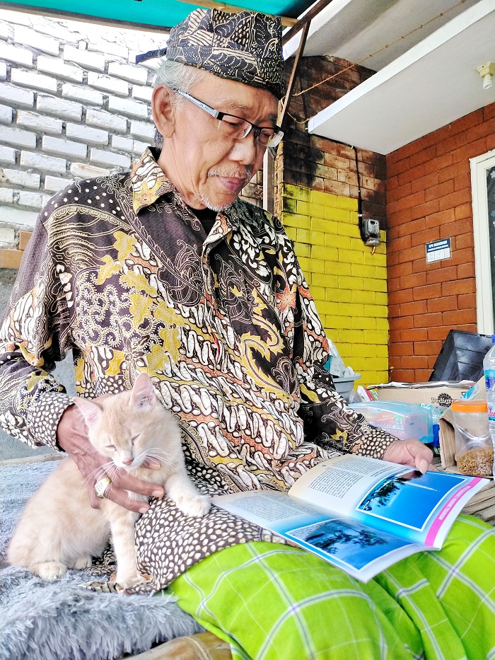 PEDULI SEJARAH: Hidrochin Sabarudin sedang membaca buku saat ditemui di rumahnya Desa Baengas, Kecamatan Labang, Bangkalan, Kamis (25/1). (VIVIN AGUSTIN HARTONO/JPRM)
