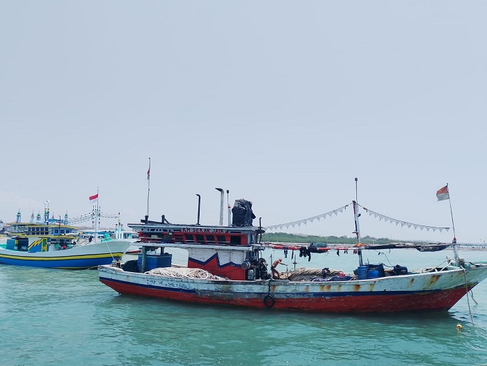 TAMBAT: Seorang nelayan menambatkan perahunya di perairan Desa Branta Pesisir, Kecamatan Tanakan, Pamekasan, Minggu (28/1). (MOH. JUNAIDI/JPRM)
