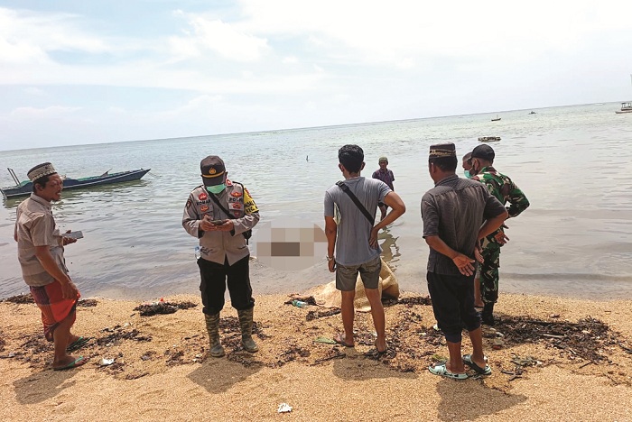 TIDAK BERNYAWA: Warga bersama petugas kepolisian mengevakuasi mayat Zainal Abidin, ABK KMN Putra Sumber Mas, di pesisir pantai Dusun Saghubing, Desa Buddhi, Kecamatan Arjasa, Sumenep, Minggu (28/1).