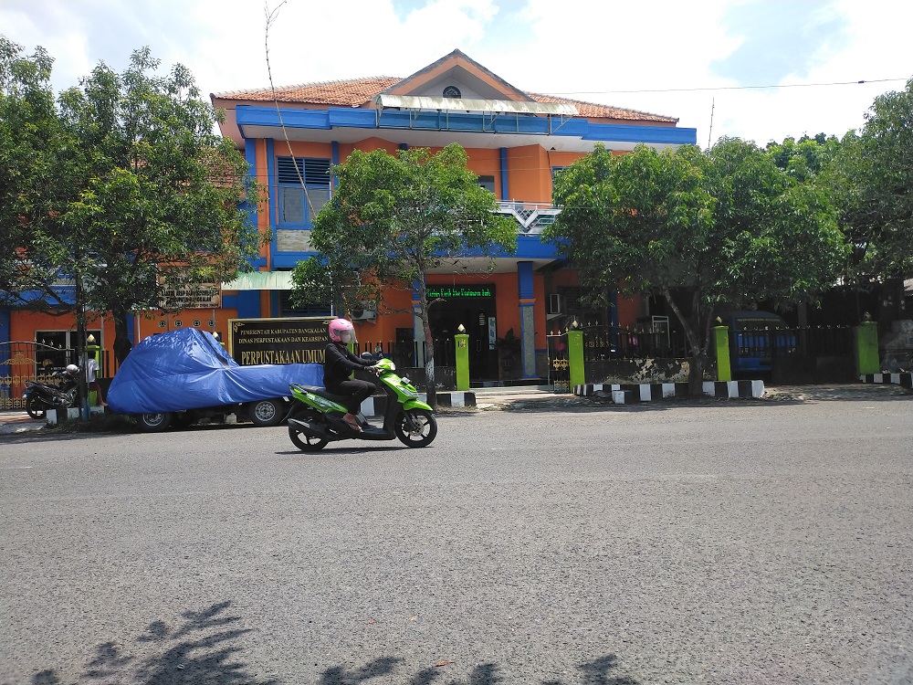 SARANA PENINGKATAN LITERASI: Pengendara melintas di depan Perpusda Bangkalan di Jalan RA Kartini, Senin (29/1). (VIVIN AGUSTIN HARTONO/JPRM)