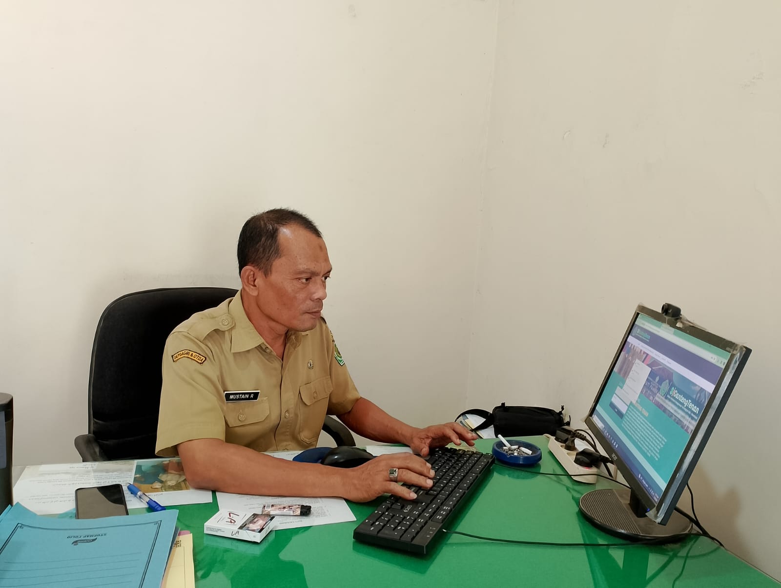 LENGANG: Kabid PPIK BKPSDM Pamekasan Mustain Ramli mengoperasikan aplikasi Siganteng di kantornya, Senin (29/1). (UBAIDILLAHIR RAIE/JPRM)