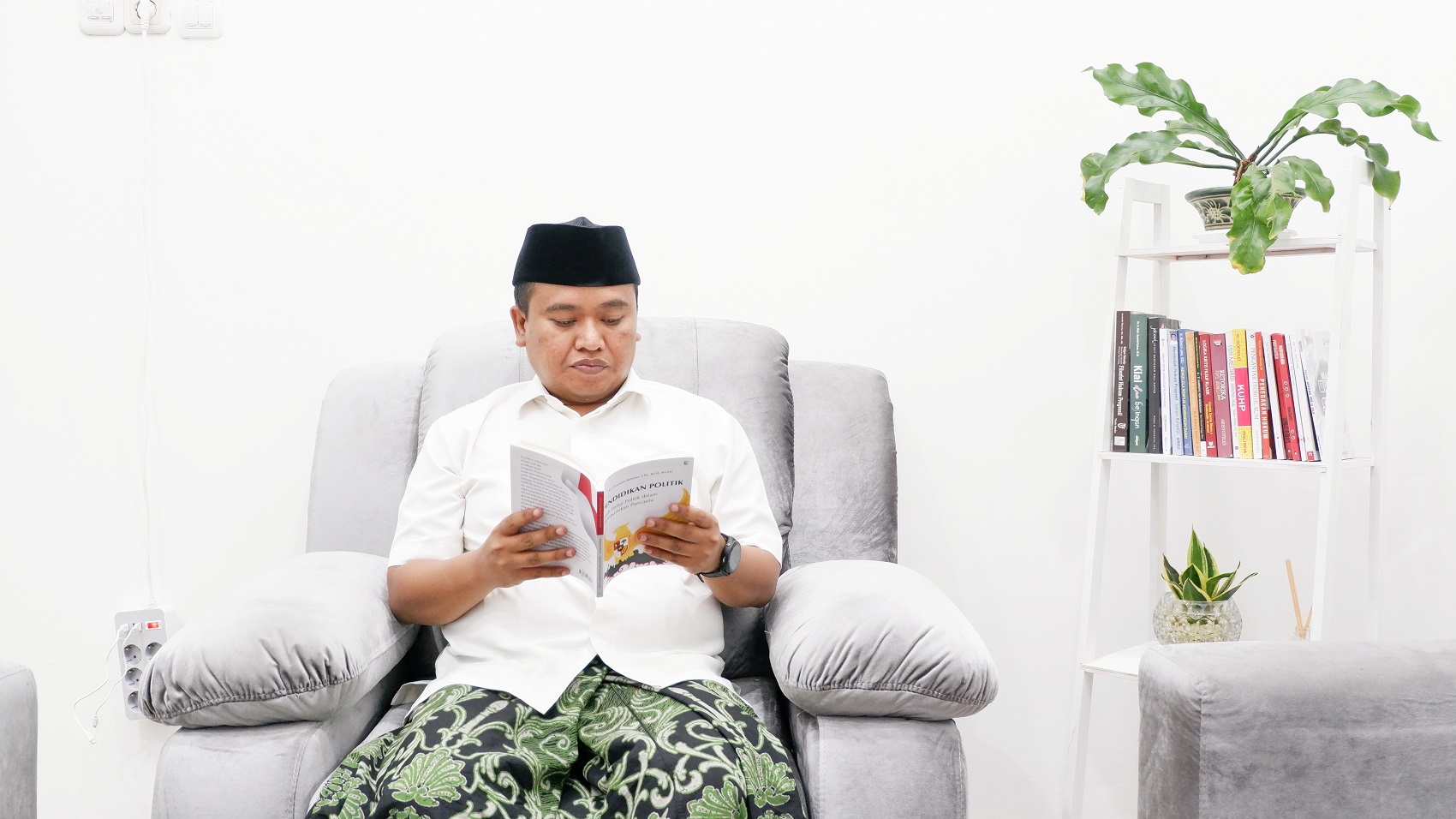 PUNYA WAWASAN: Nurul Huda membaca salah satu koleksi buku miliknya. (MOH. IQBAL AFGANI/JPRM)