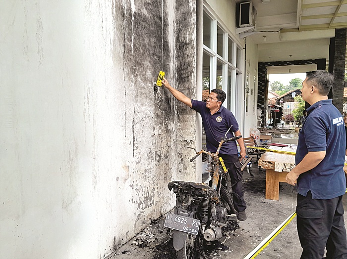 AKSI TEROR: Personel Bidlabfor Polda Jatim melakukan olah tempat kejadian perkara di rumah Sulaisi Abdurrazaq di Desa Ketawang Laok, Kecamatan Guluk-Guluk, Sumenep, Selasa (30/1). (MOH. BUSRI/JPRM)