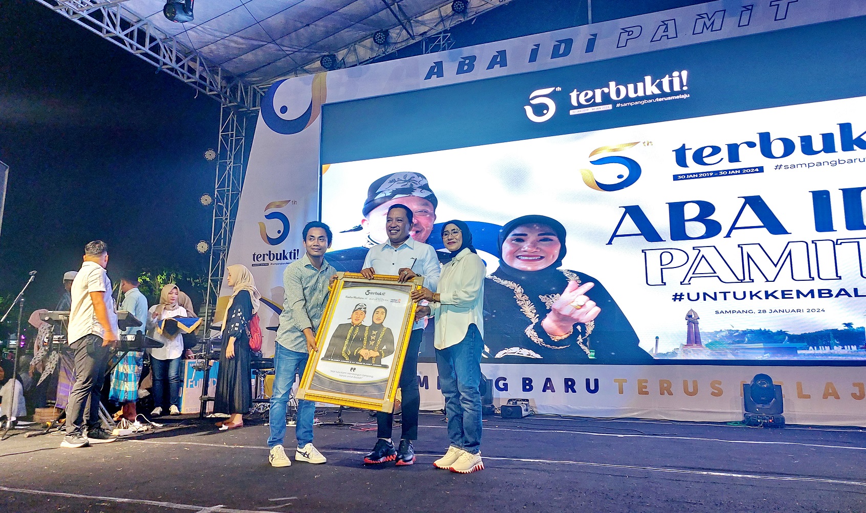 APRESIASI: Wakil Kepala JPRM Biro Sampang (kiri) menyerahkan cenderamata kepada Bupati Sampang yang didampingi istri dalam acara Pamit Aba Idi di Alun-alun Trunojoyo Minggu (28/1). (JUNAIDI P/JPRM)