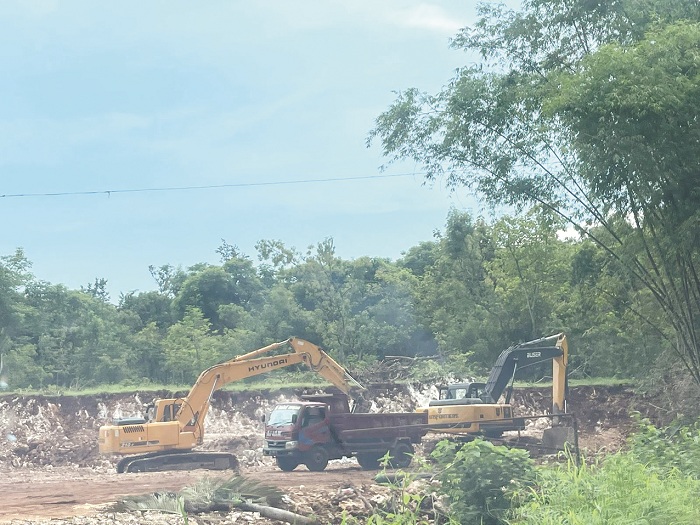 MERESAHKAN: Dua ekskavator mengisi truk dengan tanah hasil pengerukan di lokasi tambang galian C, Dusun Cemanis, Desa Langsar, Kecamatan Saronggi, Kamis (1/2). (MOH. BUSRI/JPRM)