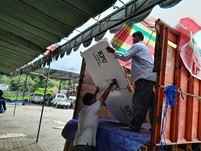 DALAM PENGAWASAN: Pekerja menaikkan bilik suara ke truk untuk didistribusikan ke kecamatan daratan dari gudang logistik KPU Sumenep, Minggu (28/1). (MOH. BUSRI/JPRM)