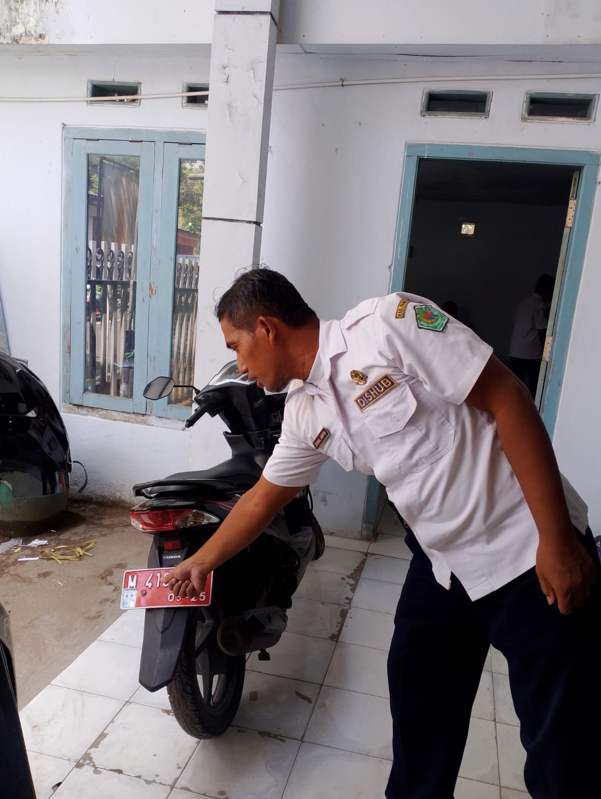 LENGANG: Karyawan Dishub Pamekasan menunjukkan contoh stiker parkir berlangganan yang terpasang pada kendaraan di kantornya, Rabu (31/1). (UBAIDILLAHIR RA&rsquo;IE/JPRM)