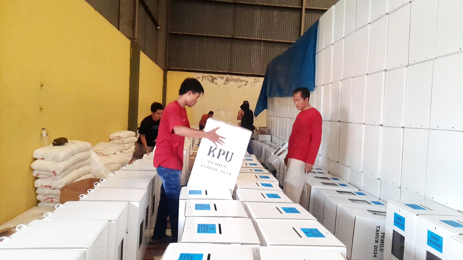 SORTIR: Pekerja KPU Pamekasan memasang stiker untuk kotak suara pemilihan umum Rabu (31/1). (KPU PAMEKASAN UNTUK JPRM)