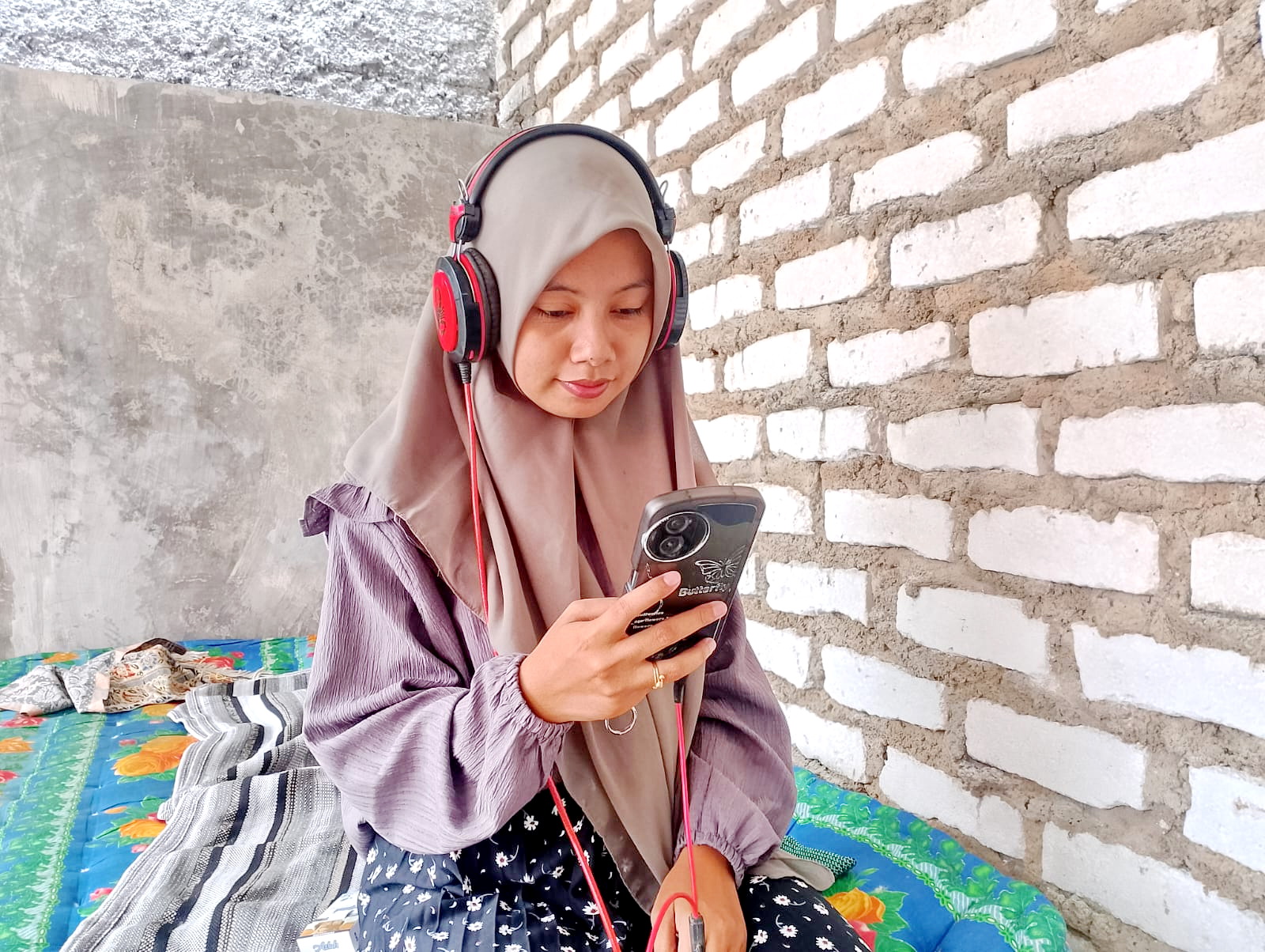 TENANG: Seorang pelajar mendengarkan musik menggunakan headset di Desa Bugih, Kecamatan Kota Pamekasan, Jumat (2/2). (UBAIDILLAHIR RA&rsquo;IE/JPRM)