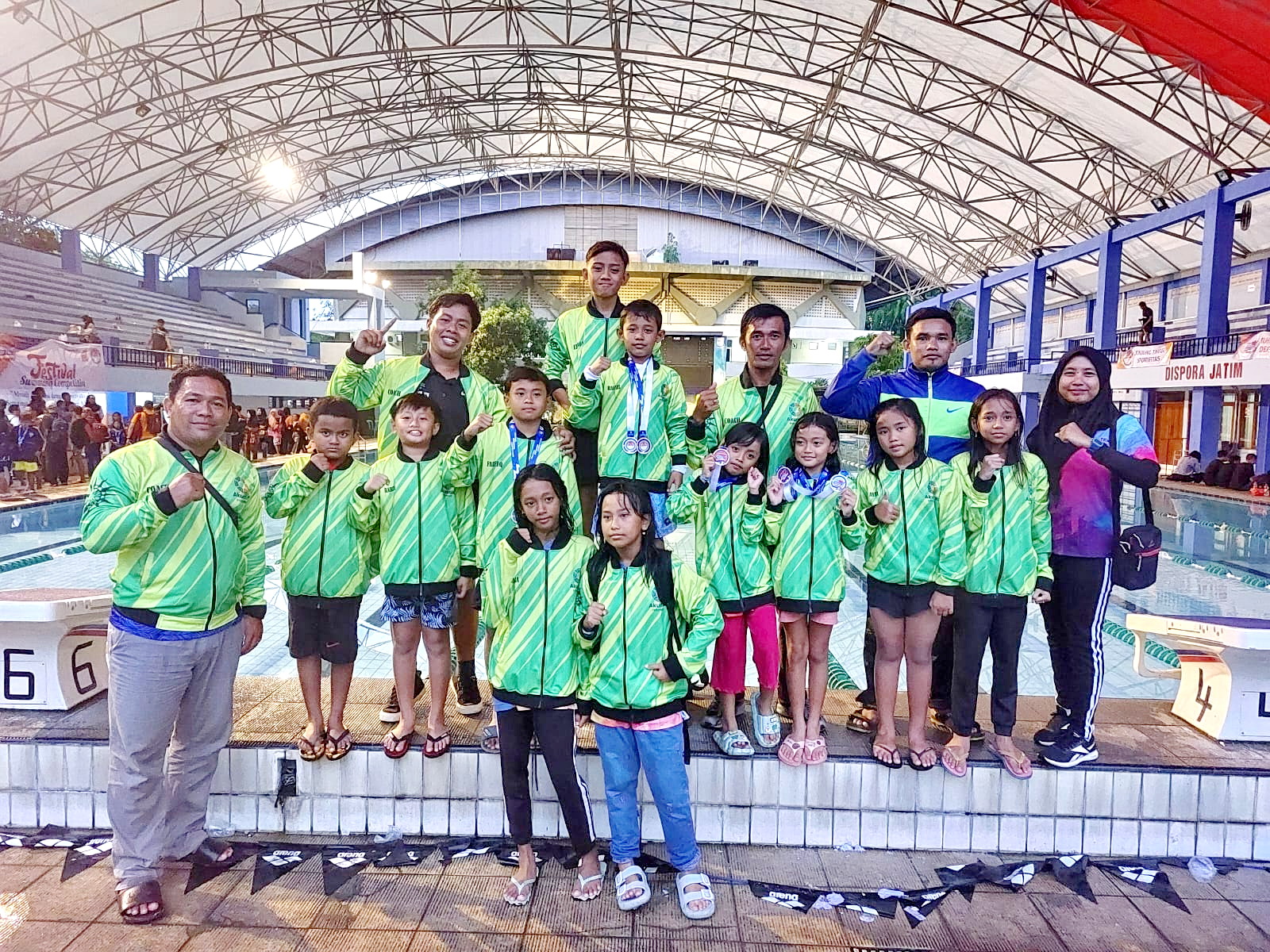 ASET MASA DEPAN: Pelatih Klub Air Terjun Bangkalan Tri Ardiyanto (kiri) foto bersama atlet binaannya usai mengikuti Festival Swimming Competition di Surabaya, Minggu (4/2). (TRI ARDIYANTO UNTUK JPRM)