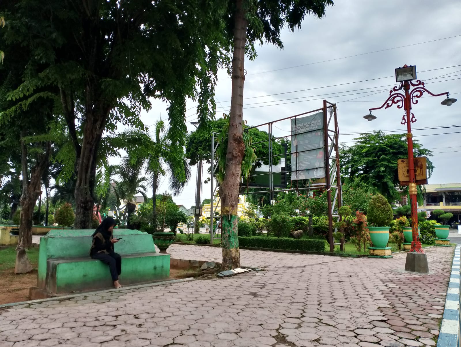 BERSANTAI: Pemuda bermain gadget di area Taman Bunga Pottre Koneng Sumenep, Rabu (7/2). (UBAIDILLAHIR RAIE/JPRM)