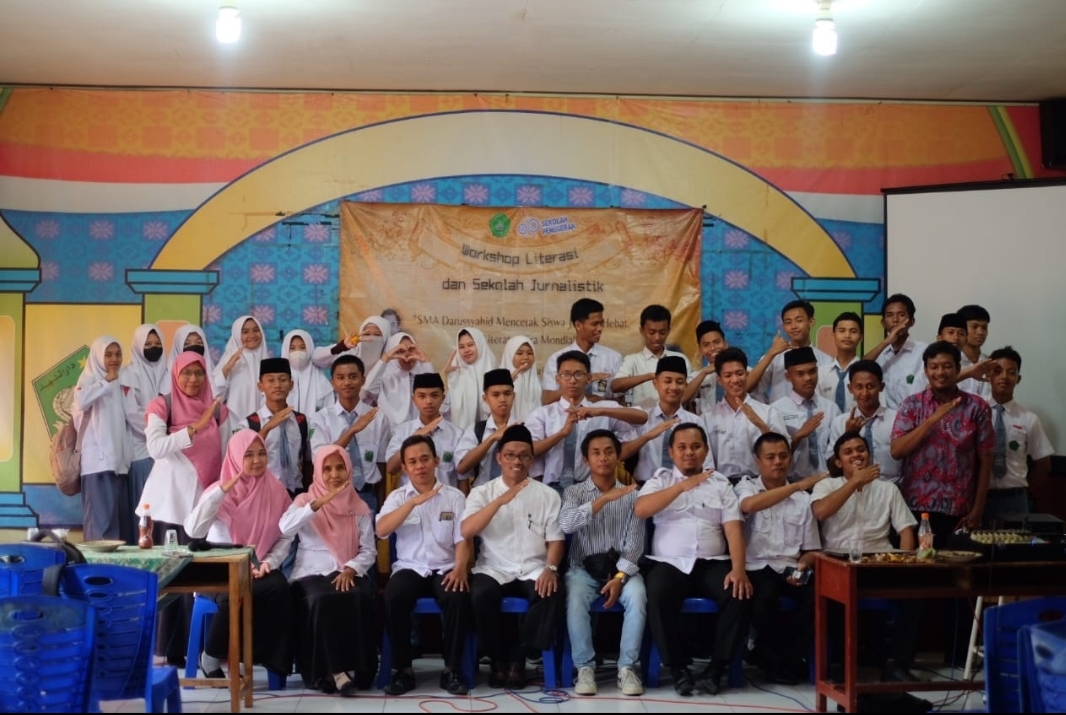 SEMANGAT: Kepala SMA Darussyahid Moh Rasyad (empat dari kiri) dan Wakil Kepala JPRM Biro Sampang Darul Hakim (lima dari kiri) foto bersama guru dan siswa dalam acara sekolah jurnalistik, Rabu (7/2).