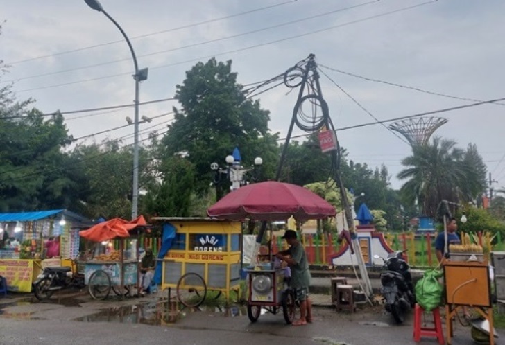 MENDUNG: Pedagang kaki lima menjaga lapaknya di sepanjang Jalan Suhadak, Kota Sampang, Minggu (10/2).