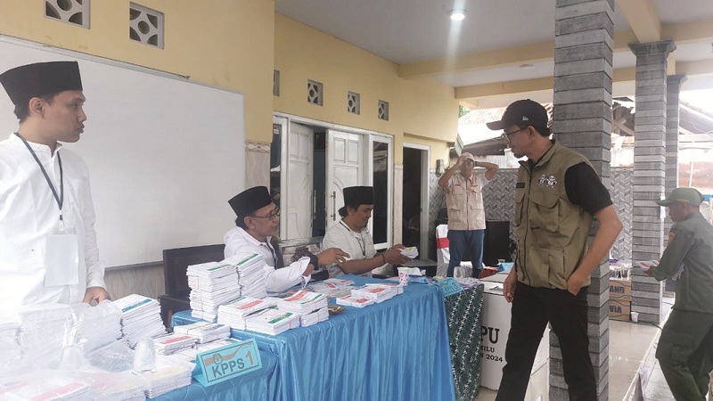 TURUN LANGSUNG: Ketua KPU Sampang Addy Imansyah (pakai rompi) saat meninjau pelaksanaan pemilu di TPS 05 Kelurahan Banyuanyar, Kecamatan Sampang, Rabu (14/2). (JUNAIDI PONDIYANTO/JPRM)