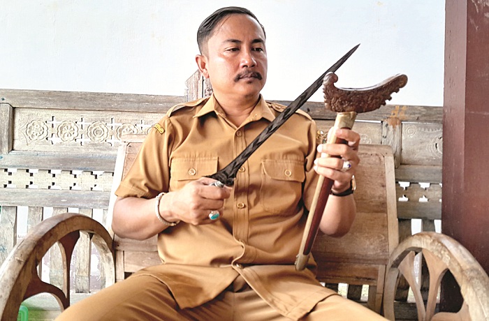 KARYA BUDAYA: Kades Aeng Tongtong, Kecamatan Saronggi, Sumenep, Hadi Sudirfan menunjukkan sebilah keris Tresno Gati miliknya saat ditemui di Balai Galeri Keris, Senin (12/2). (MOH. BUSRI/JPRM)