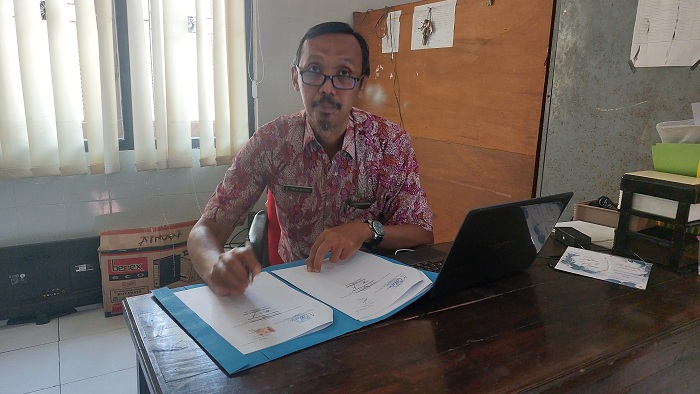 RAPI: Kabid Penempatan Perluasan Tenaga Kerja dan Transmigrasi Dinas Tenaga Kerja Sampang Uriantono Triwibowo membaca berkas di ruang kerjanya Kamis (15/2). (JUNAIDI PONDIYANTO/JPRM)