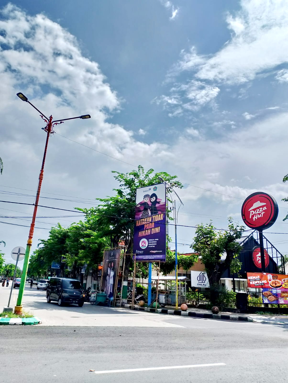 EDUKASI: Pengendara melintas di sekitar reklame edukasi dinas P3AKB di Jalan Masegit, Pamekasan. Senin (19/2). (UBAIDILLAHIR RA&rsquo;IE/JPRM)