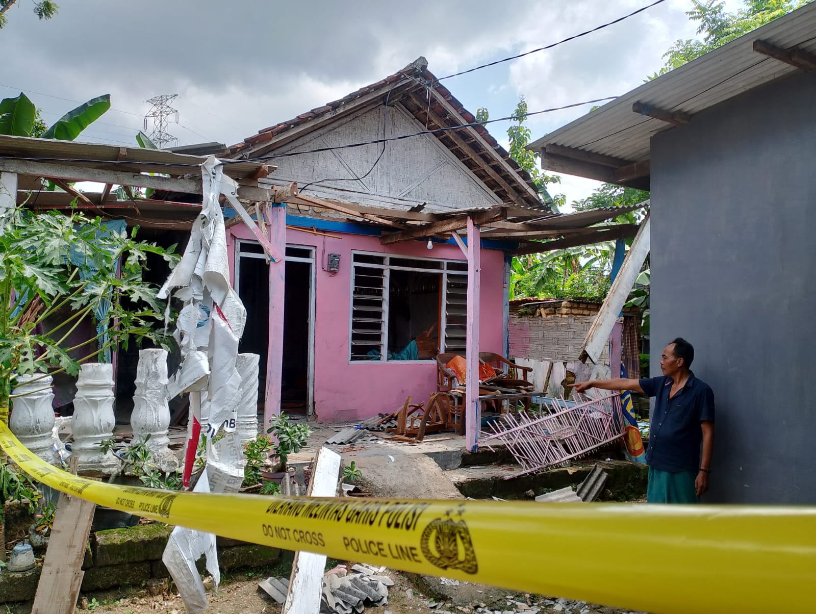 DILARANG MELINTAS: Kusyairi menunjukkan rumahnya yang berantakan karena ledakan di Desa Nyalabu Daya, Kecamatan Kota Pamekasan, Selasa (20/2). (UBAIDILLAHIR RAIE/JPRM)