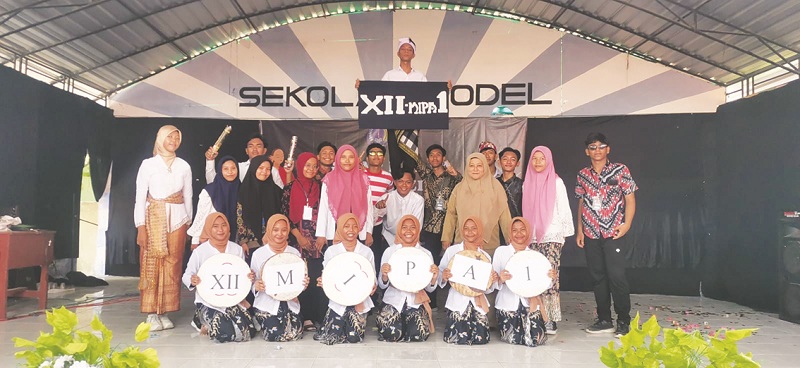 BERPENDIDIKAN: Kepala SMA Negeri 2 Sampang Lely Herawati (baju cokelat) bersama siswanya di SMAN 2 Sampang Selasa (20/2). (SOKARNO/JPRM)