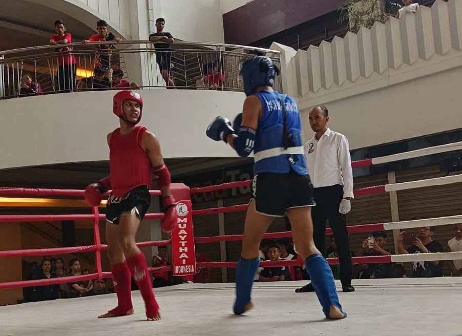 PENUH SEMANGAT: Atlet Muay Thai Pamekasan Ahyatullah Aulia Mirza (sabuk biru) saat bertanding di kejuaraan Super Fight SLC Cup Road to Thailand, Minggu (18/2). (ARY BUDIARTO UNTUK JPRM)