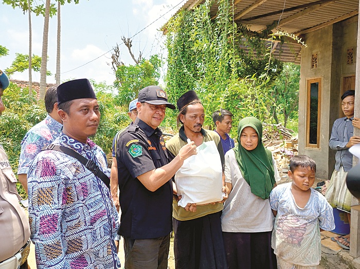 PEDULI: Pj Bupati Pamekasan Masrukin memberikan bantuan sembako kepada Moh. Sobri, korban angin puyuh di Desa Blumbungan, Kecamatan Larangan, Kamis (22/2). (LAILIYATUN NURIYAH/JPRM)