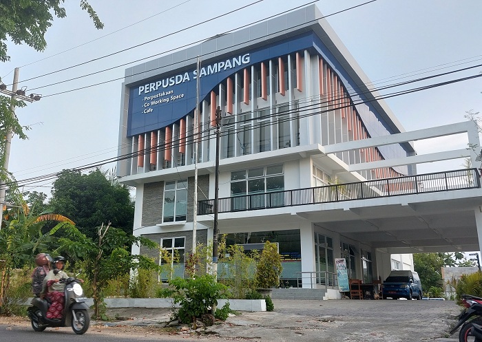 MEGAH: Warga berada di depan gedung Perpustakaan Daerah Sampang yang berlantai empat di Jalan Merapi, Kecamatan Kota, Kamis (22/2). (JUNAIDI PONDIYANTO/JPRM)