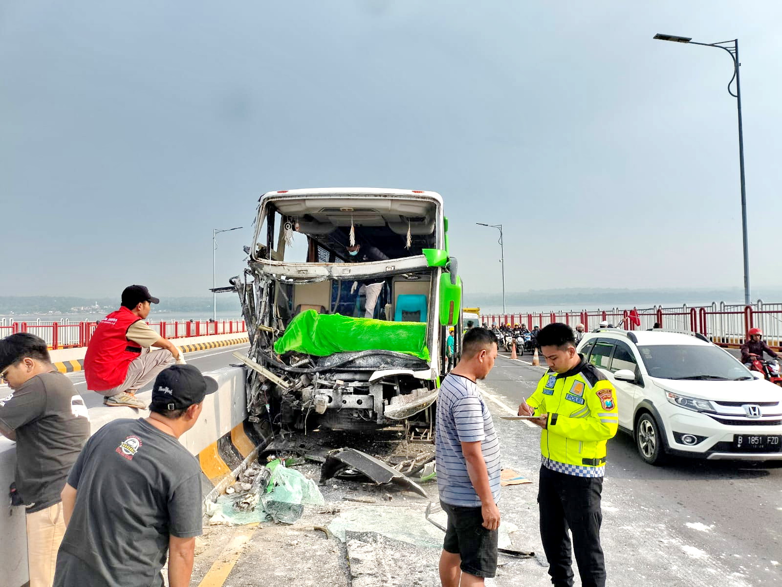 RINGSEK: Anggota Unit Laka Lantas Polres Bangkalan meminta keterangan saksi seusar terjadi kecelakaan di Jembatan Suramadu, Sabtu (24/2). (SATLANTAS POLRES BANGKALAN UNTUK JPRM)