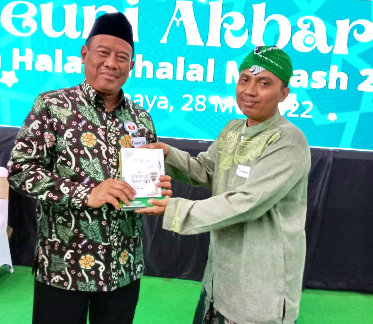 PEJUANG KERAS: Direktur Muara Progresif Surabaya Achmad Tirmidzi Munahwan (kanan) memberikan buku terbitan Muara Progresif kepada Kepala Kanwil Kemenag Jatim Husnul Maram. (TIRMIDZI UNTUK JPRM)