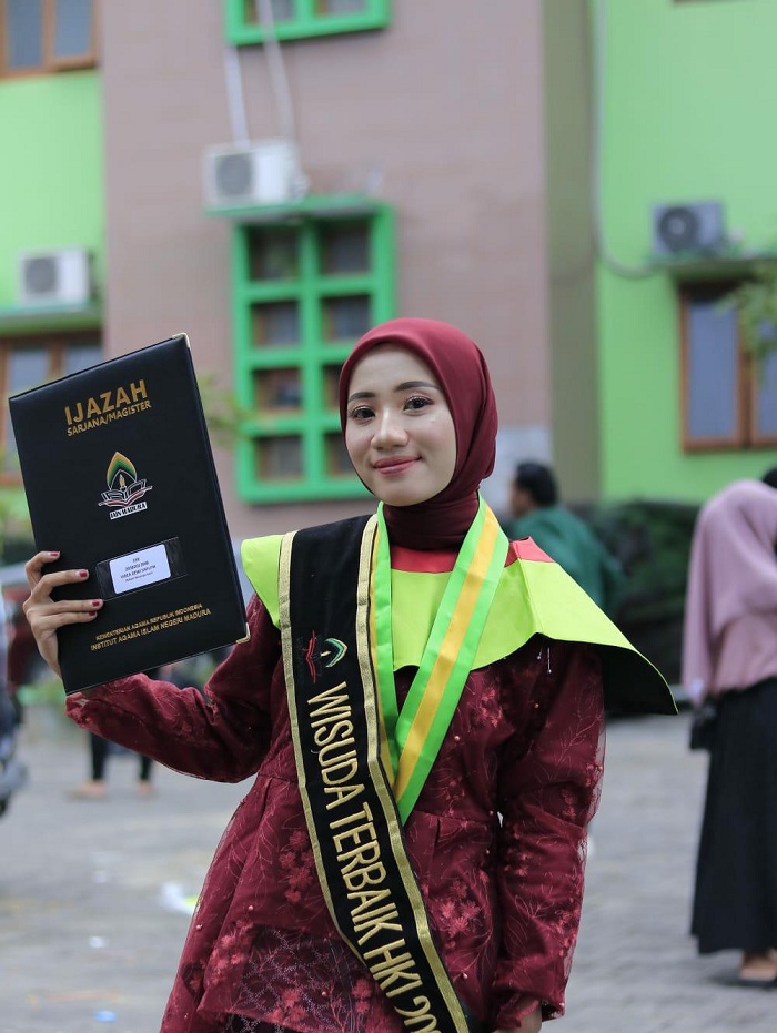 SENANG: Wisudawan terbaik prodi HKI IAIN Madura Videa Dewi Saputri menunjukkan ijazah usai diwisuda, Rabu (28/2). (MOH. IQBAL AFGANI/JPRM)