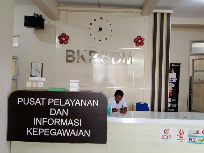 BERTUGAS: Pegawai BKPSDM Sampang sedang bertugas di bagian resepsionis Senin (4/3). (UBAIDILLAHIR RA&rsquo;IE/JPRM)