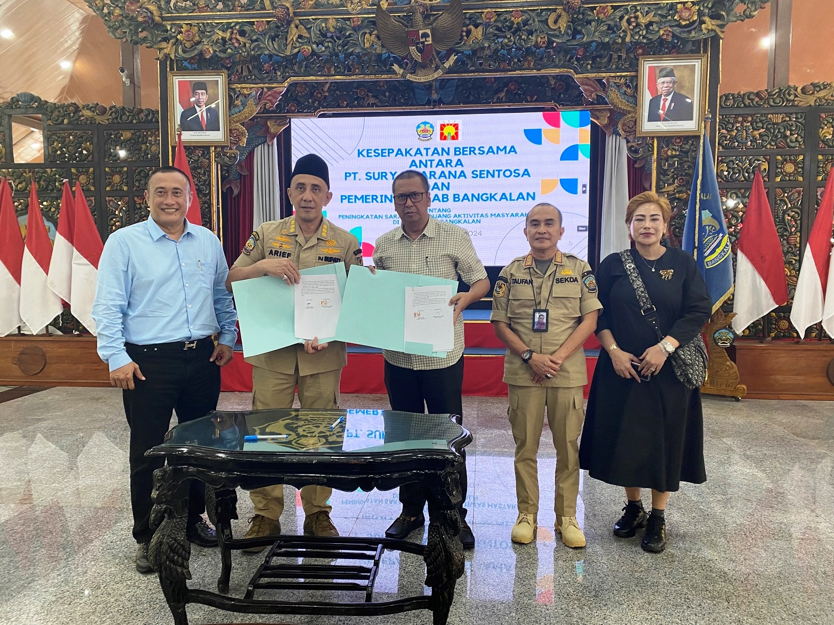 MITRA: Pj Bupati Bangkalan bersama pimpinan PT Surya Sarana Sentosa menunjukkan dokumen MoU pengelolaan Gedung Serbaguna Rato Ebuh yang telah ditandatangani di Pendopo Agung Senin (4/3). (JUPRI/JPRM)