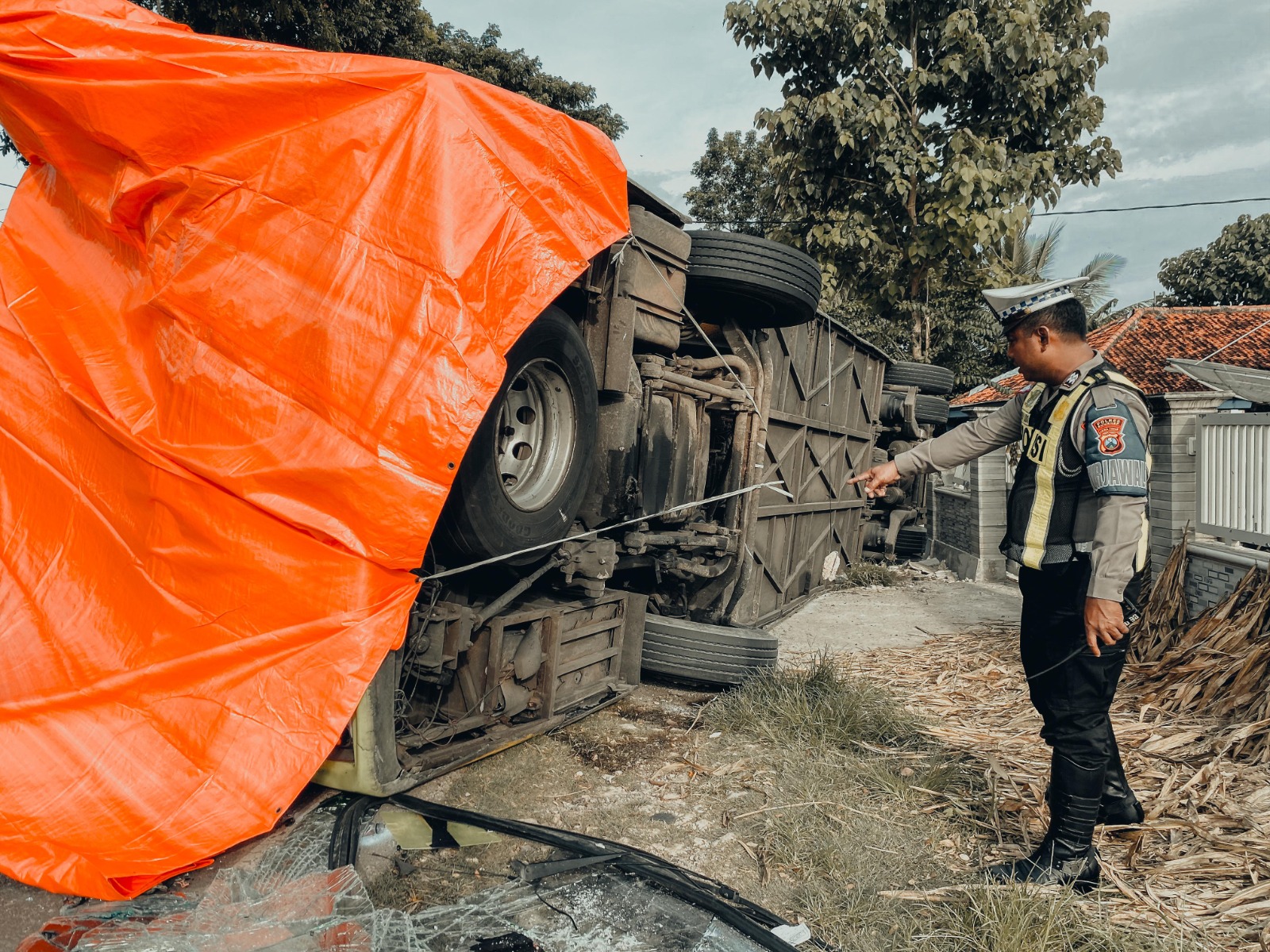 TERGULING: Petugas kepolisian melalukan evakuasi terhadap Bus Gunung Harta yang terguling di jalan nasional, Desa Aengdake, Kecamatan Bluto, Sumenep. (MOH. JUNAIDI/JPRM)