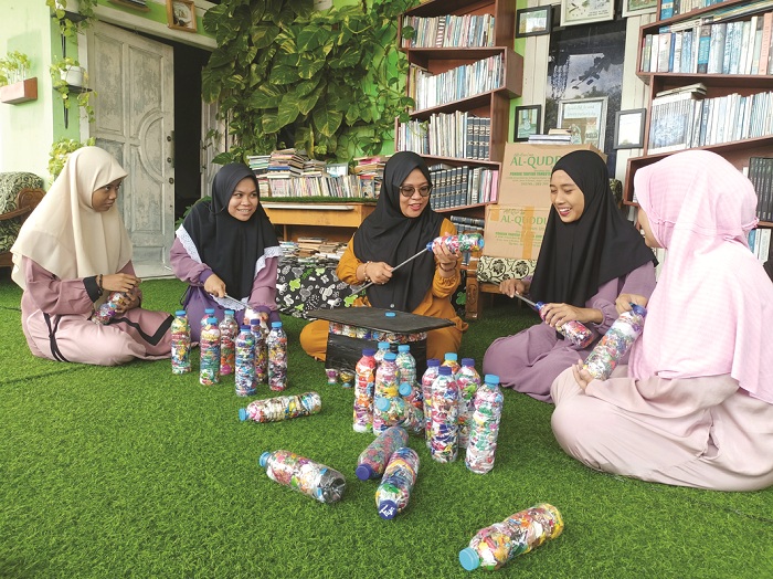 KREATIF: Pengasuh Pondok Pesantren Tahfidzul Qur&rsquo;an Al Karimiyyah Putri Virzannida Busyro (tengah) sedang mengajari santrinya mendaur ulang sampah plastik di pondoknya, Jumat (8/3). (MOH. IQBAL/JPRM)