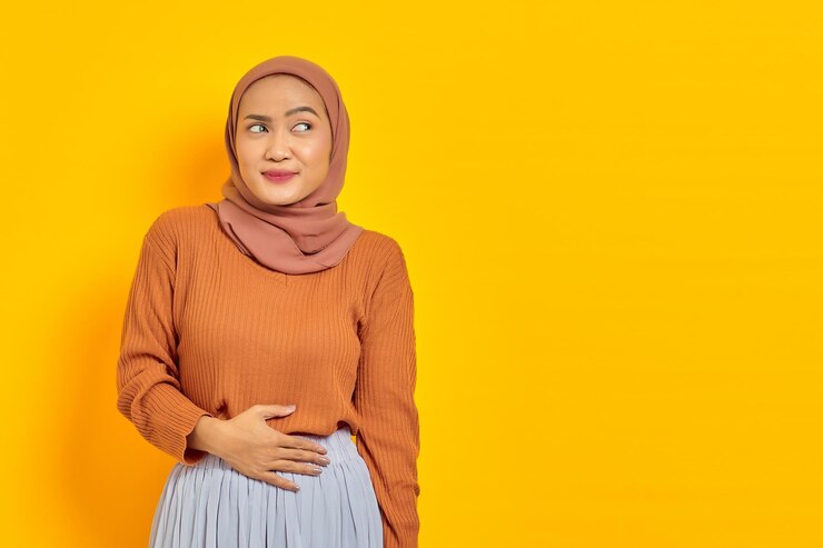 Seorang Perempuan Tengah Menyentuh Perutnya