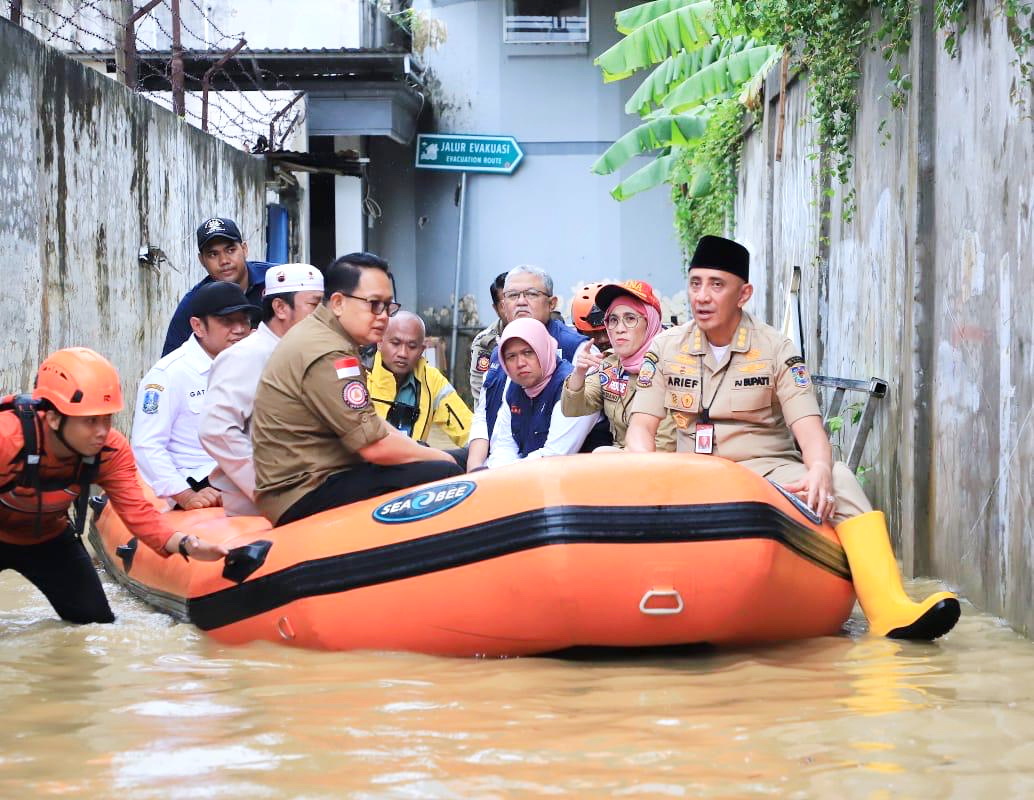 TANGGAP: Pj Gubernur Jatim Adhy Karyono (kiri, berkacamata) bersama jajarannya didampingi Pj Bupati Bangkalan Arief M. Edie menyusuri daerah banjir menggunakan perahu karet di Kecamatan Blega