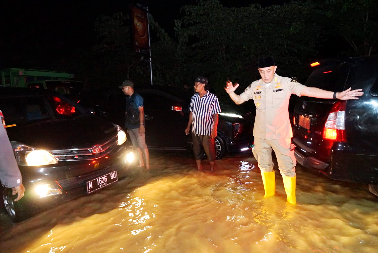 TERGENANG: Pj Bupati Bangkalan Arief M. Edie mengawal kendaraan yang melintas di ruas jalan nasional, Kecamatan Blega, Rabu (13/3) dini hari.