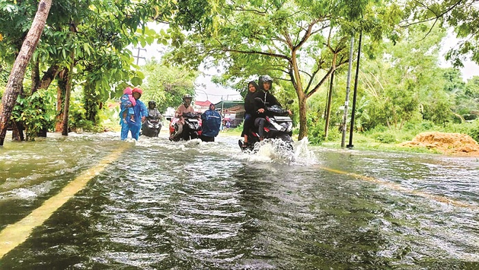 BERHATI-HATI: Pengendara roda dua saat menerobos genangan air banjir di Jalan Raya Arosbaya, Bangkalan, Rabu (13/3). (ZEINAL ABIDIN/JPRM)