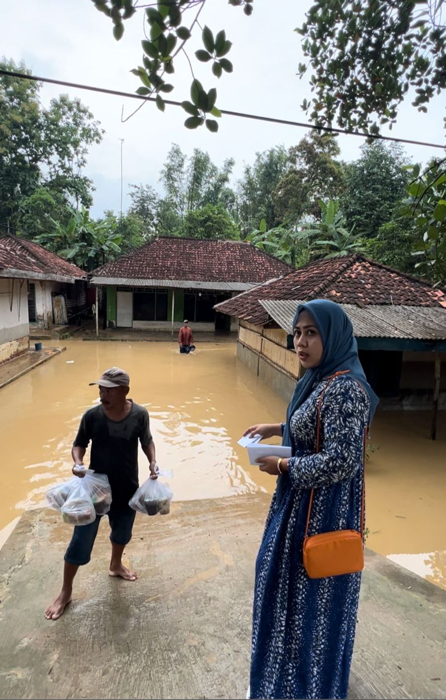 PEDULI: Anggota Komisi IV DPRD Kabupaten Sampang Hj. Sri Rustiana, S.Kep memberikan bantuan kepada korban banjir di Desa/Kecamatan Tambelangan, Sampang pada selasa (12/3) sore.