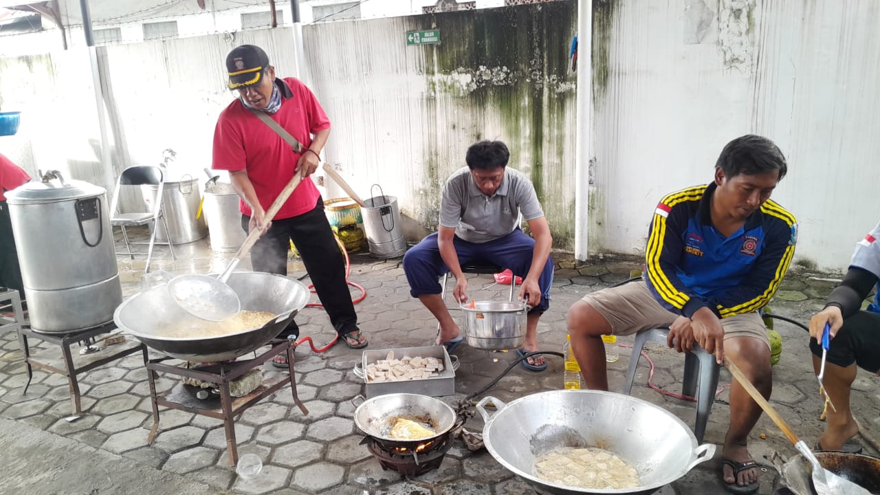 MASAK: Tim relawan saat memasak di dapur umum Dinsos Sampang untuk pendistribusian nasi bungkus kepada para korban banjir.