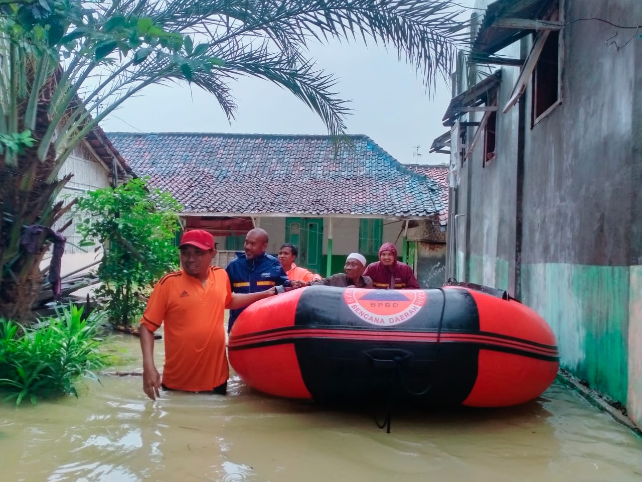 MULAI TINGGI: Kasi Kedaruratan dan Logistik (KL) BPBD Sampang Mohammad Hozin bersama tim mengevakuasi lansia di Jl. Ajigunung Kelurahan Gunung Sekar, Sampang, Rabu (13/3).