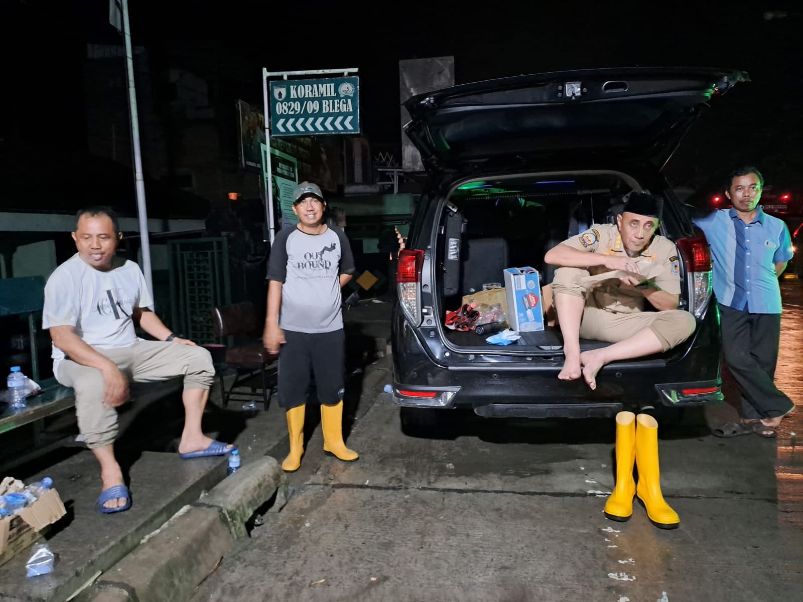 DEMI WARGA: Pj Bupati Bangkalan Arief M. Edie sahur nasi bungkus di bagasi mobilnya saat meninjau banjir di Kecamatan Blega.&nbsp;