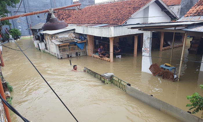 TERENDAM: Warga berada di area terdampak banjir di Kelurahan Rongtengah, Kecamatan Kota Sampang, Rabu (13/3). (DIMAS UNTUK JPRM)