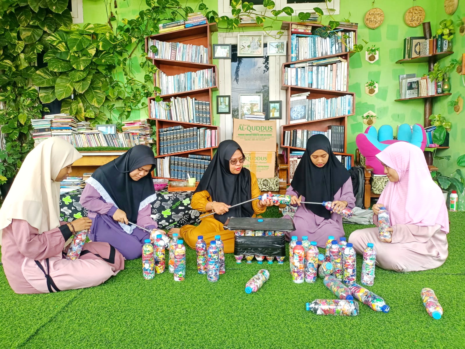 KREATIF: Pengasuh Pondok Pesantren Tahfidzul Qur&rsquo;an Putri Al Karimiyyah Virzannida Busyro (tengah) mengajari santri cara mendaur ulang sampah plastik di ponpesnya pada Jumat (8/3). (MOH IQBAL/JPRM)