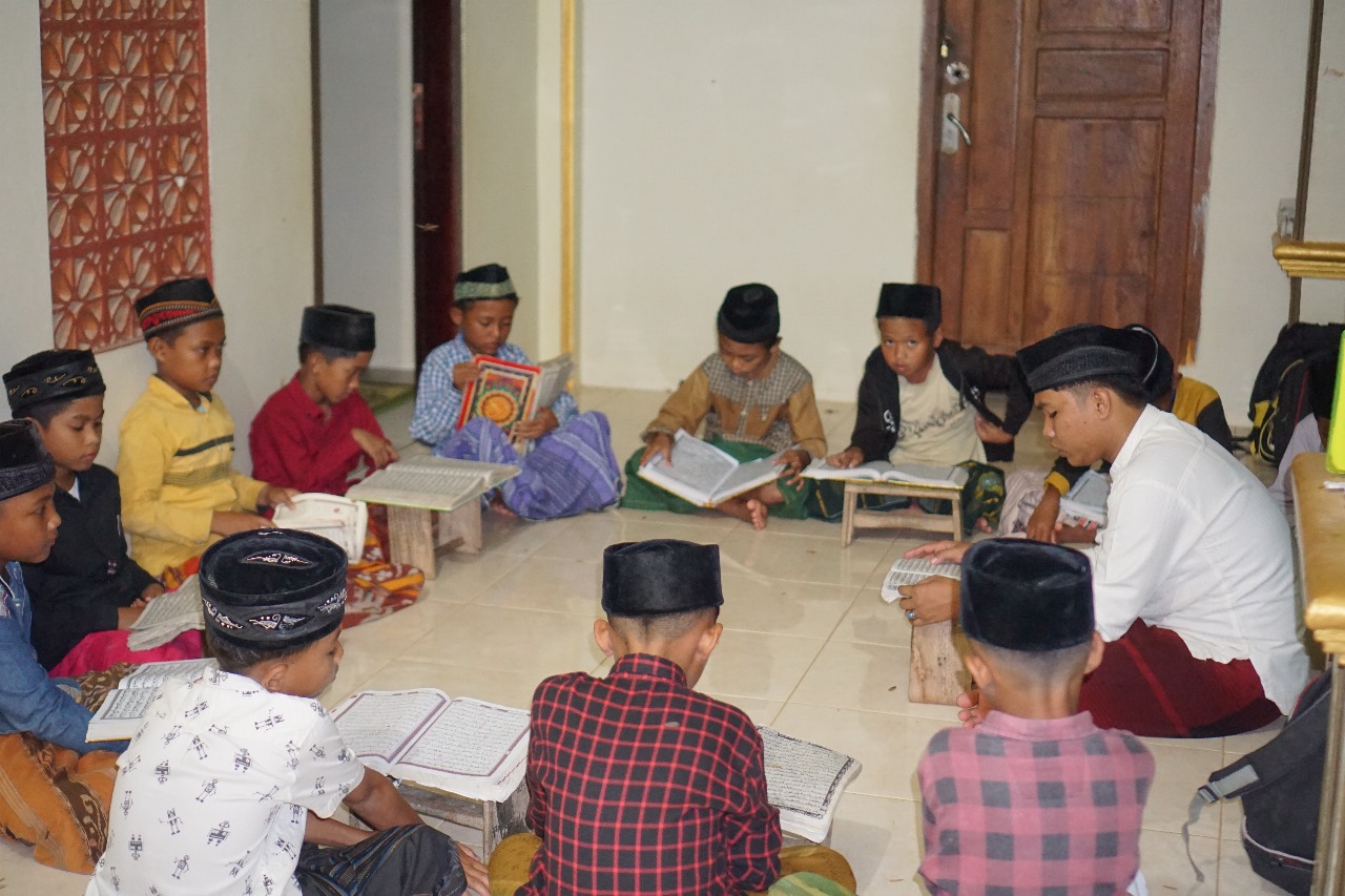 MENYIMAK: Murid pemula MMU Nurus Salam Kebun Anum tadarusan guru bantu dari Ponpes Taman Sari, Desa Palengaan Laok, Kecamatan Pelengaan, Pamekasan, Ustad Shofa Khoirul Wafa. (MMU NUSAKA)