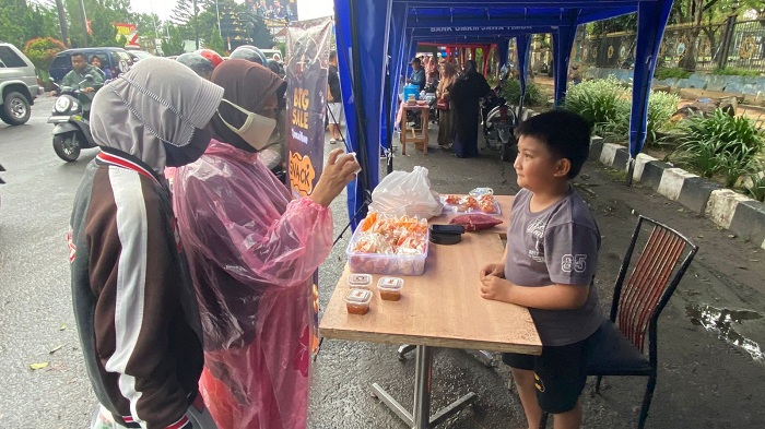 SERU: Rizki Ramadan Hartawan saat menjaga stan bazar takjil di Jalan Letnan Abdullah, Bangkalan, Kamis (14/3). (AYU LATIFAH/JPRM)