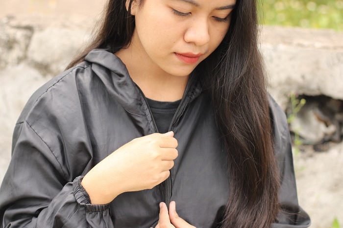 SPORTI: Putri Nanda Sari memperbaiki jaket croptop parasut di Jalan Kini Balu, Bangkalan, Rabu (28/2). (VIVIN AGUSTIN HARTONO/JPRM)