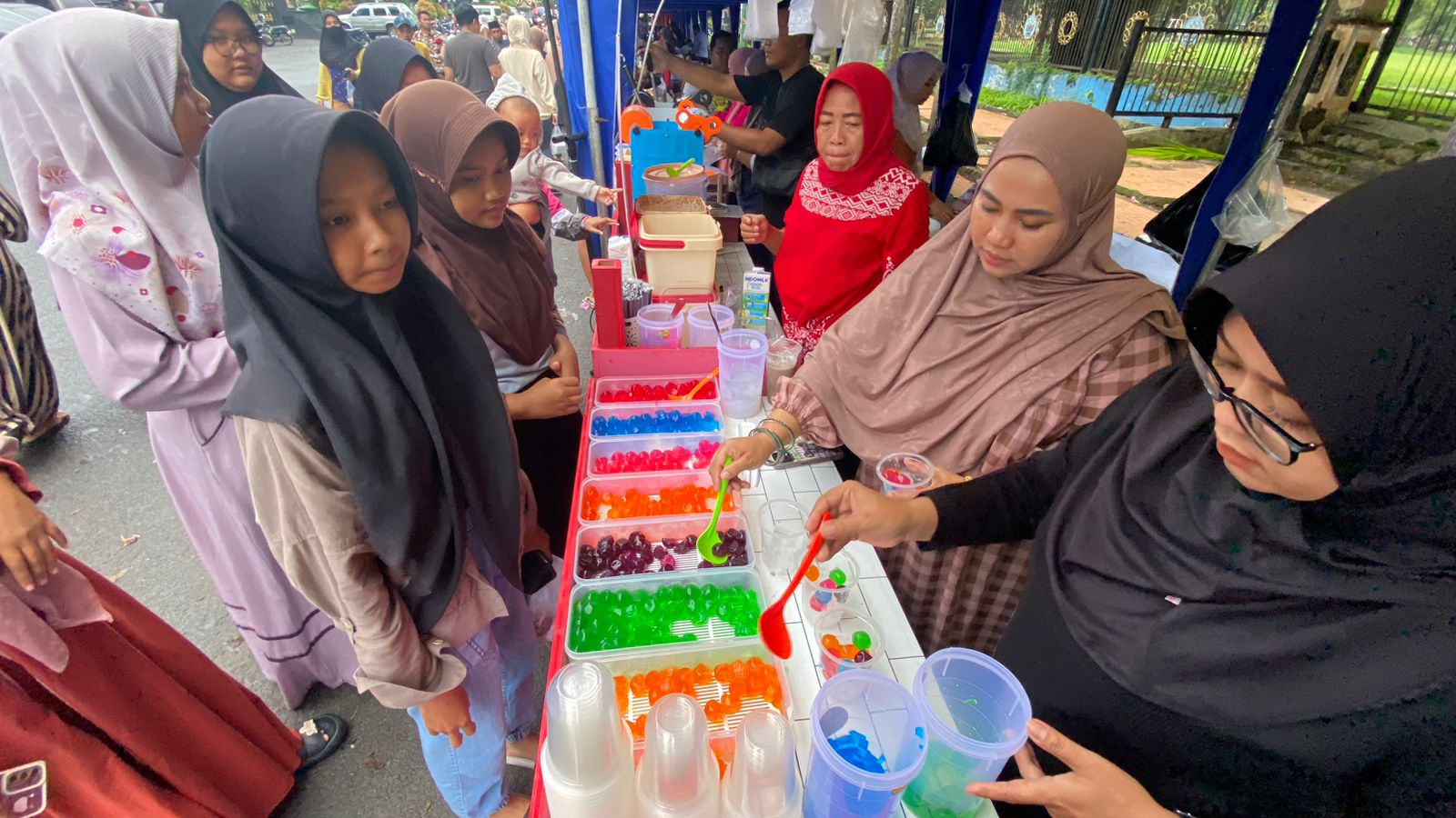 UNIK: Fitria Harianto (baju cokelat) sibuk melayani pembeli es jelly ball di Bazar Takjil Ramadan Bangkalan, Kamis (14/3). (AYU LATIFAH/JPRM)