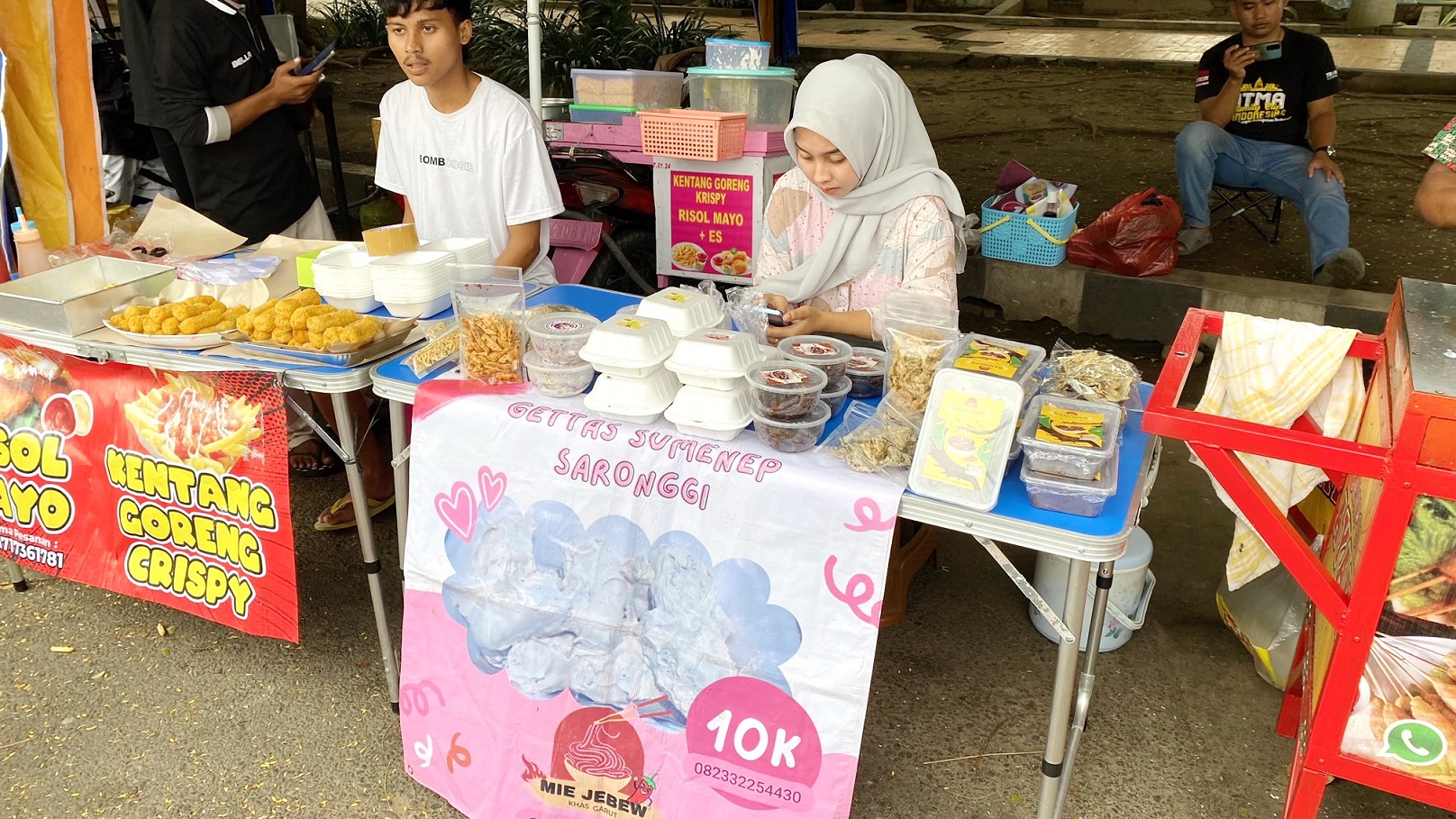 TRADISIONAL: Tri Andini Nur Amalia (berkerudung) menjaga stan Bazar Takjil Ramadan di Jalan Letnan Abdullah, Bangkalan, Minggu (17/3). (AYU LATIFAH/JPRM)